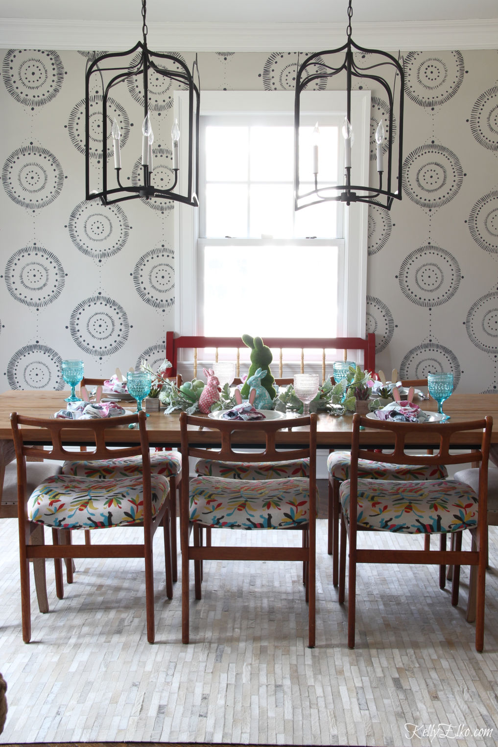 Love this hand painted wall mural and pair of huge lanterns in this dining room kellyelko.com #diningroom #diningroomdecor #murals #lighting #diningroomlighting #midcenturymodern #diningroomfurniture #ourarticle #article #bohodecor #eclecticdecor #springdecor #springtable #eastertable #cowhide #otomi 