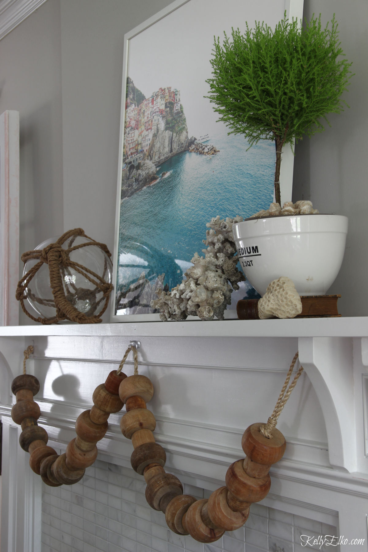 Love the big chunky wood beads on this coastal summer mantel kellyelko.com #summer #mantel #summermantel #coastal #coastaldecor #topiary 