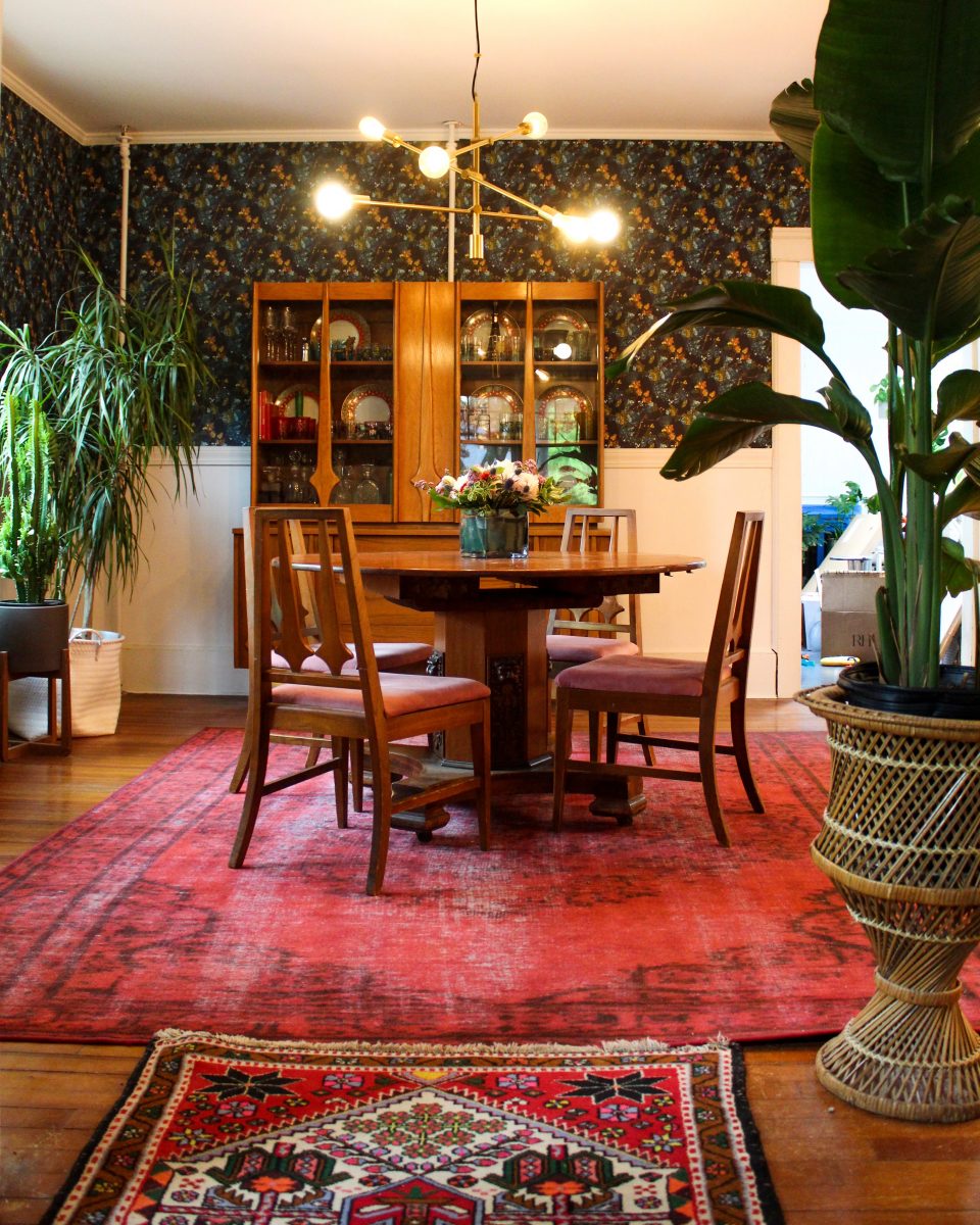 Colorful boho dining room filled with thrift store vintage finds and colorful antique rugs kellyelko.com #diningroom #diningroomdecor #vintagedecor #lighting #vintagemodern #plantlady #vintagerugs #midcenturymodern