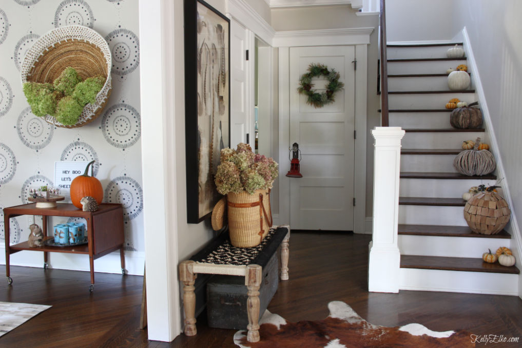 Fall home tour - love the staircase of neutral pumpkins and the huge wall basket filled with hydrangeas kellyelko.com #foyer #foyerdecor #falldecor #falldecorating #basket #bohodecor #vintagedecor #pumpkins #pumpkindecor #entrydecor 