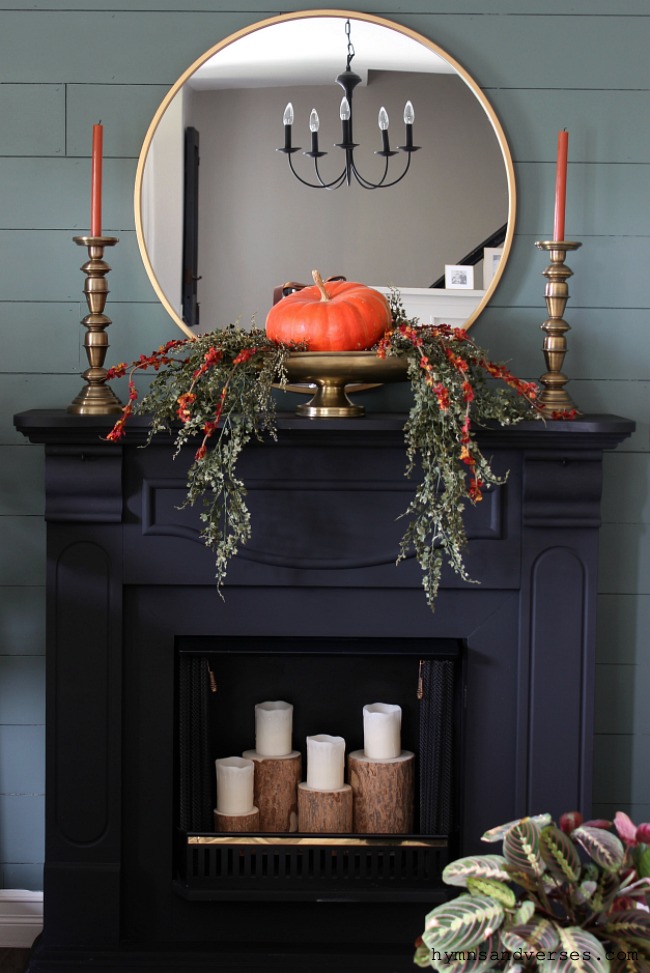 12 Creative Fall Mantels - love this moody black mantel with single pumpkin in an urn kellyelko.com #falldecor #fallmantel #mantel #manteldecor #pumpkins #blackpaint #shiplap #fireplace