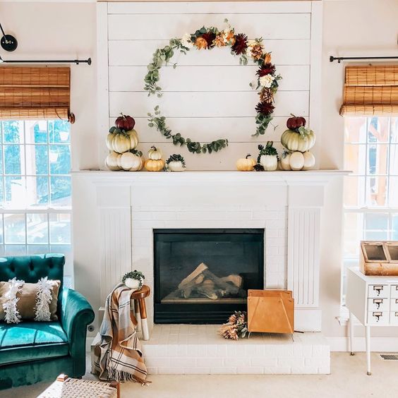 12 Creative Fall Mantels - love this DIY floral wreath and stacked pumpkins kellyelko.com #fall #falldecor #fallmantel #diywreath #wreaths #diycrafts #neutraldecor #farmhousedecor #shiplap #manteldecor 