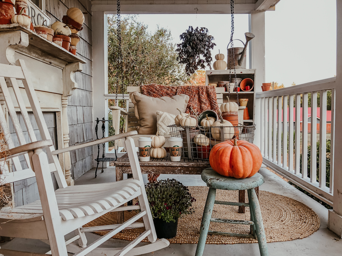 Farmhouse front porch decorated for fall - love the chippy wood mantel and piles of pumpkins kellyelko.com #fall #falldecor #fallporch #farmhousedecor #farmhouseporch #porchdecor #frontporch #farmhousestyle 