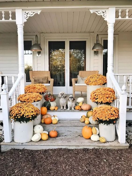 10 Beautiful Fall Porches - love the vintage crocks used as planters kellyelko.com #fall #fallporch #falldecor #falldecorating #mums #pumpkins #vintagefall #vintagedecor #farmhousedecor #porch #frontporch #curbappeal #autummdecor #autummporch