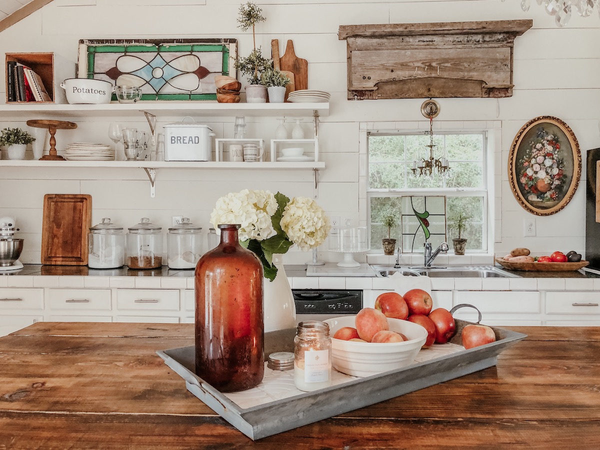 Love this farmhouse kitchen with shiplap walls and open shelves for vintage displays kellyelko.com #kitchendecor #vintagedecor #whitekitchen #farmhousedecor #farmhousekitchen #eclecticdecor #shiplapkitchen #openshelves 