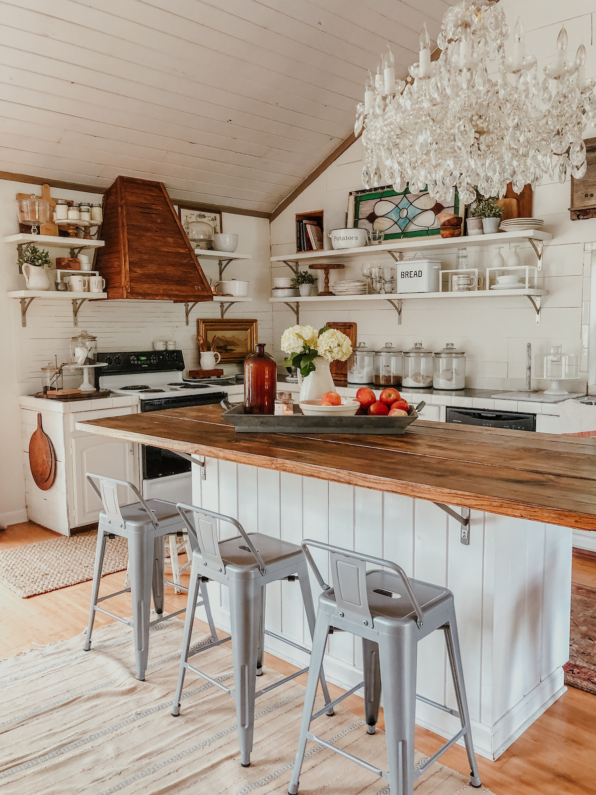 Beautiful farmhouse kitchen with shiplap, open shelves, crystal chandelier and DIY wood range hood kellyelko.com #farmhousedecor #farmhousekitchen #falldecor #kitchen #kitchendecor #whitekitchen #shiplapkitchen #vintagedecor 