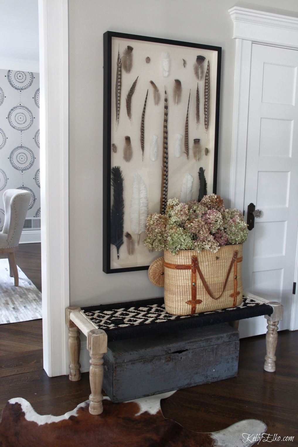 Love this foyer with huge feather art and basket of dried hydrangeas kellyelko.com #foyer #fallfoyer #entrydecor #hydrangeas #vintagedecor #falldecor 