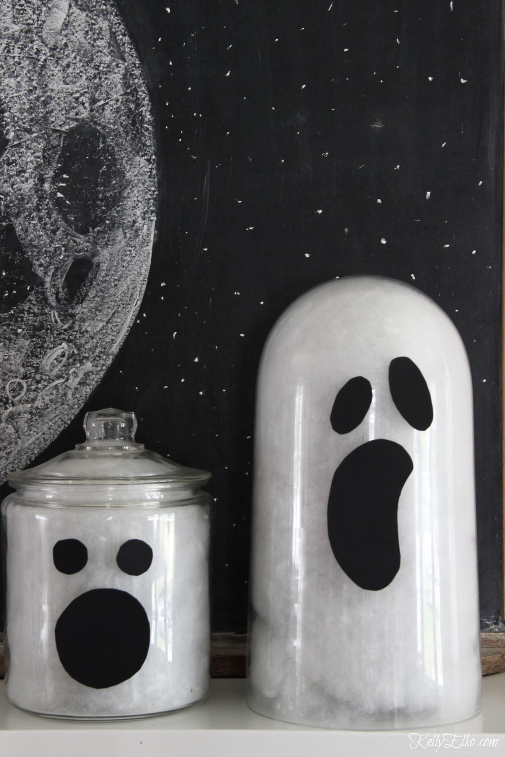 See how to make these cute glass jar ghosts for Halloween kellyelko.com #ghosts #halloweendecor #halloweendecorations #diyhalloween #halloweencrafts #halloweenmantel 