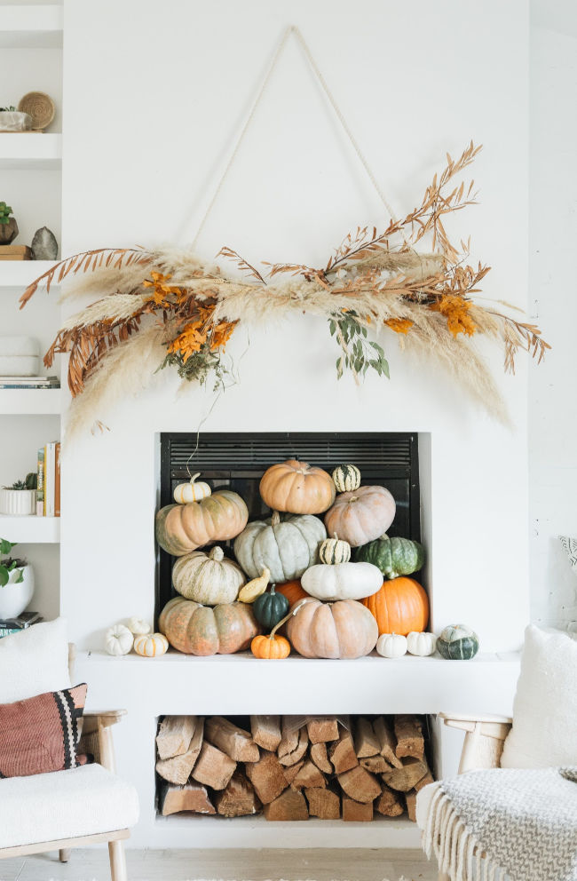 12 Creative Fall Mantels - this huge DIY pampas grass and wheat wall hanging is beautiful kellyelko.com #fall #falldecor #fallcrafts #diyideas #pumpkins #fallmantel #mantels #bohodecor 