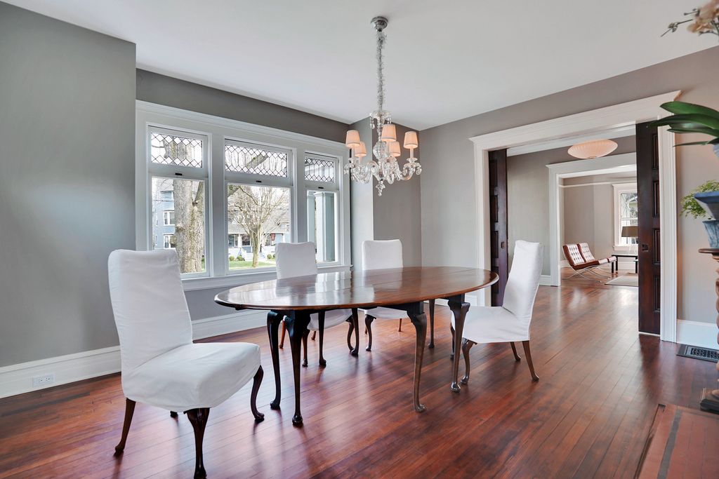 This old house has beautiful diamond paned windows and hardwood floors kellyelko.com #diningroom #diningroomdecor #oldhouse #oldhome #interiordecor #interiordesign #graypaint #slipcoverchairs #diningroomfurniture #vintagemodern 