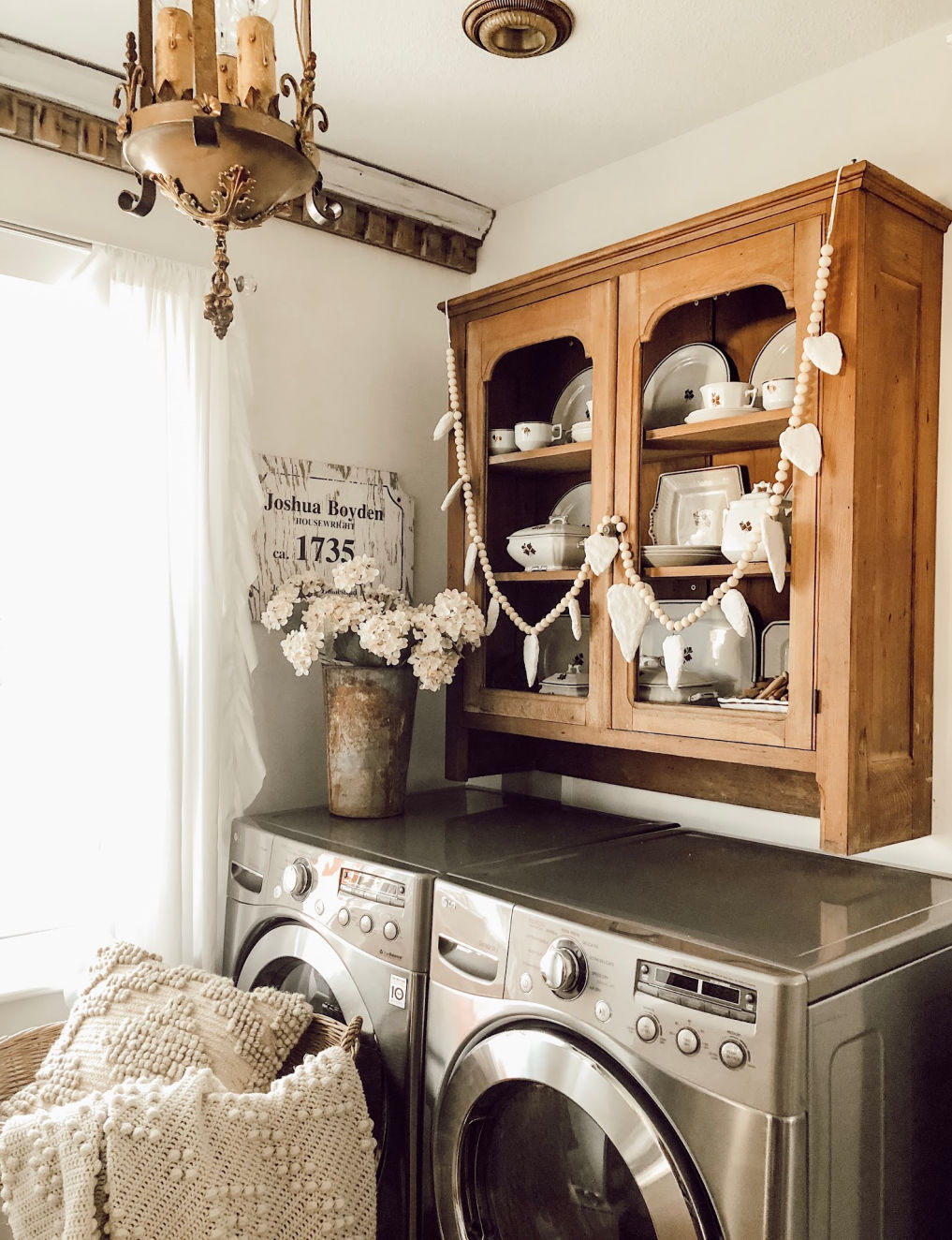 Laundry room with a vintage cabinet over the washer and dryer #farmhousedecor #vintagedecor #farmhouselaundryroom #laundryroom #neutraldecor #cottagestyle 