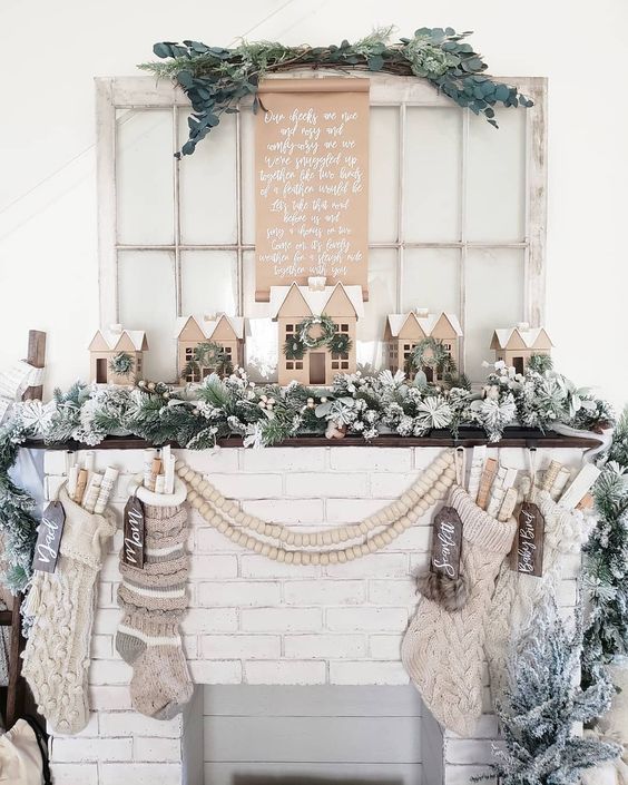 Neutral Christmas mantel with cardboard houses kellyelko.com #christmas #neutralchristmasdecor #christmasmantel #putzhouses #christmasstockings #farmhousechristmas #vintagechristmas #kellyelko #christmasdecorating