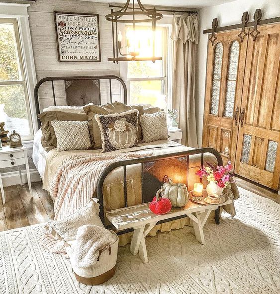 Beautiful farmhouse bedroom with iron bed and old doors turned rolling barn doors kellyelko.com #farmhouse #farmhousedecor #farmhousebedroom #vintagedecor #vintagebedroom #fall #falldecor 