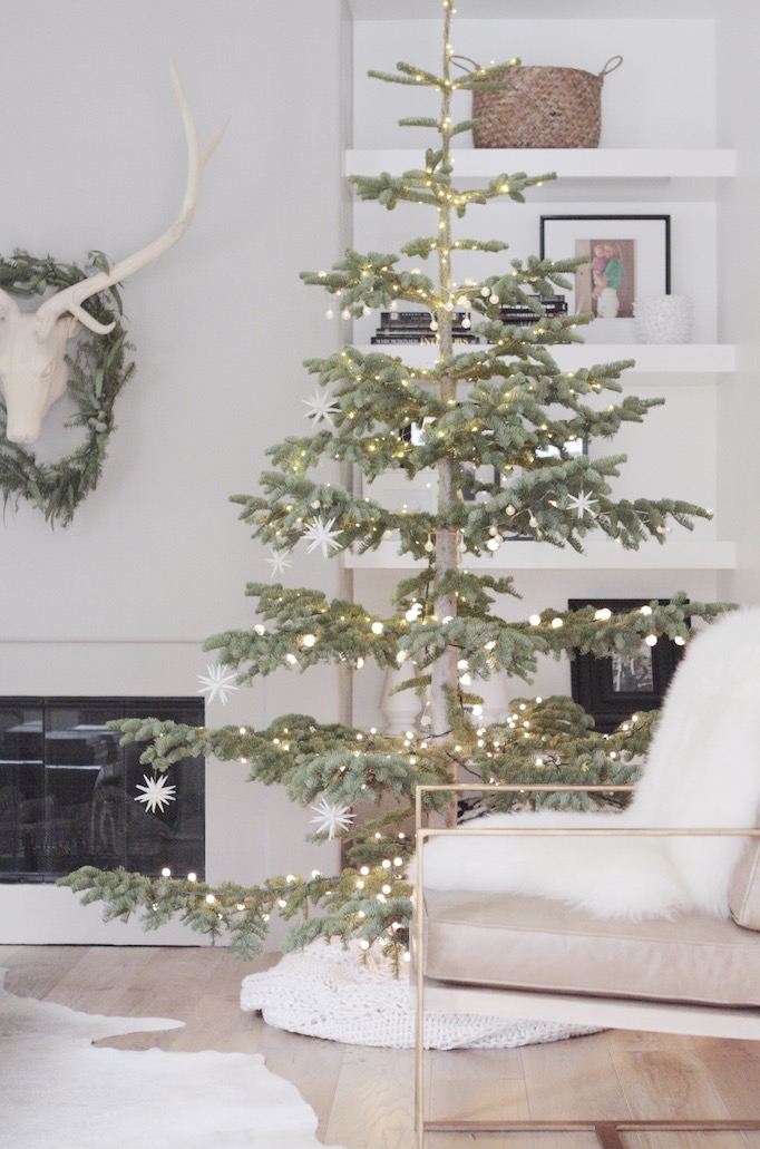 15 Sparse Christmas Trees - love this beautiful Silver Tip tree minimally decorated in lights and stars kellyelko.com #christmas #christmastree #sparsechristmastree #vintagechristmas #christmasdecor #christmasedecorating #christmasdecoratingideas #farmhousechristmas #christmasornaments #neutralchristmas #silvertip #kellyelko