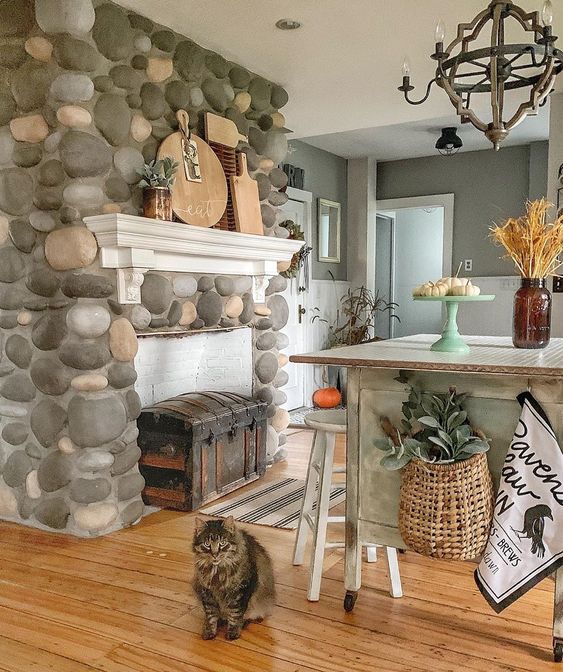 This beautiful stone fireplace separates the kitchen from the breakfast nook in this old farmhouse kellyelko.com #fireplace #farmhouse #farmhousekitchen #farmhousestyle #countrykitchen #cottagekitchen #vintagedecor
