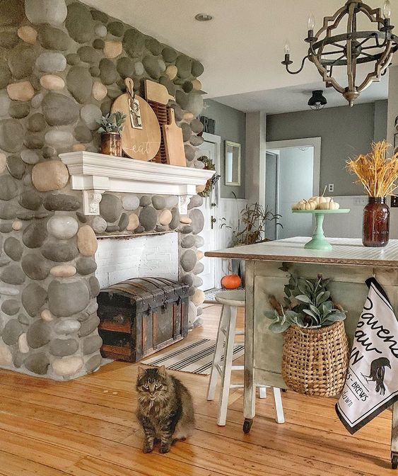 This beautiful stone fireplace separates the kitchen from the breakfast nook in this old farmhouse kellyelko.com #fireplace #farmhouse #farmhousekitchen #farmhousestyle #countrykitchen #cottagekitchen #vintagedecor 