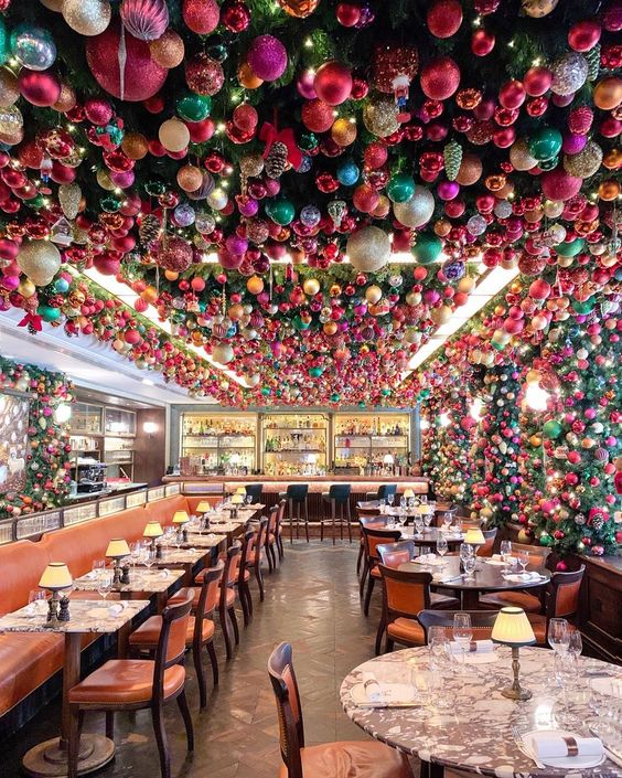 The ceiling of this festive restaurant is covered in Christmas ornaments kellyelko.com #christmas #christmasdecor #christmasdecorations #34mayfair #colorfulchristmas #londonchristmas #londonrestaurants #shinybrites #ornaments 