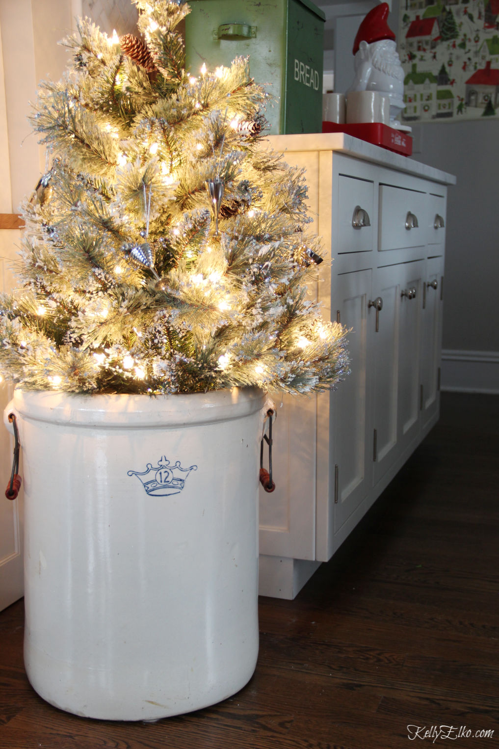 Beautiful vintage modern Christmas home tour - love the antique crock holding a Christmas tree kellyelko.com #christmas #christmasdecor #christmasdecorating #christmashome #christmastour #diychristmas #christmasideas #christmasmantel #christmastree #christmasornaments #vintagechristmas #farmhousechristmas #colorfulchristmas #creativechristmas #kellyelko #crock #vintagecrock #christmaskitchen 