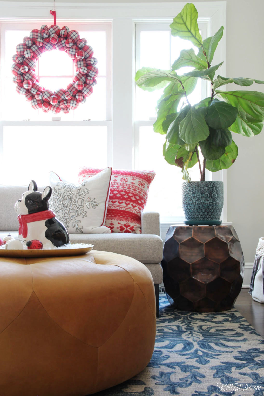 Creative Christmas Home Tour - love this colorful family room with huge red plaid wreath and fiddle leaf fig kellyelko.com #christmas #christmasdecor #christmasdecorating #christmashome #christmastour #diychristmas #christmasideas #christmasmantel #christmastree #christmasornaments #vintagechristmas #farmhousechristmas #colorfulchristmas #creativechristmas #kellyelko #fiddleleaffig #houseplants #plants #plantlady 