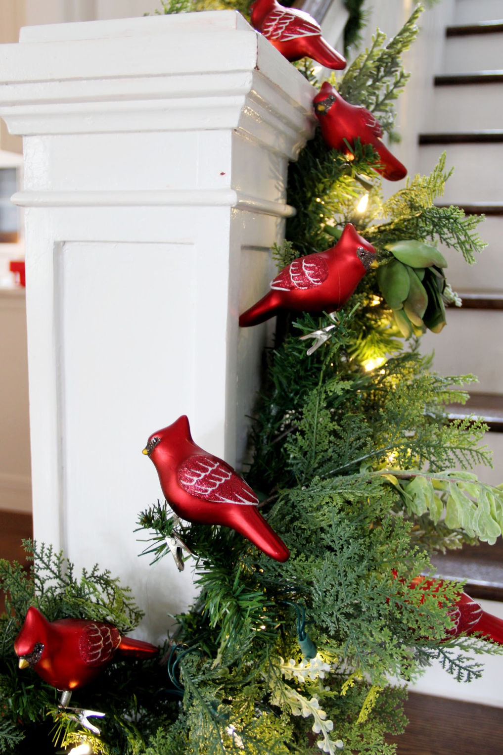 Christmas garland filled with red cardinal ornaments kellyelko.com #christmas #christmasdecor #christmasdecorating #christmashome #christmastour #diychristmas #christmasideas #christmasmantel #christmastree #christmasornaments #vintagechristmas #farmhousechristmas #colorfulchristmas #creativechristmas #kellyelko #cardinals #bannister #christmasgarland #christmasstairs