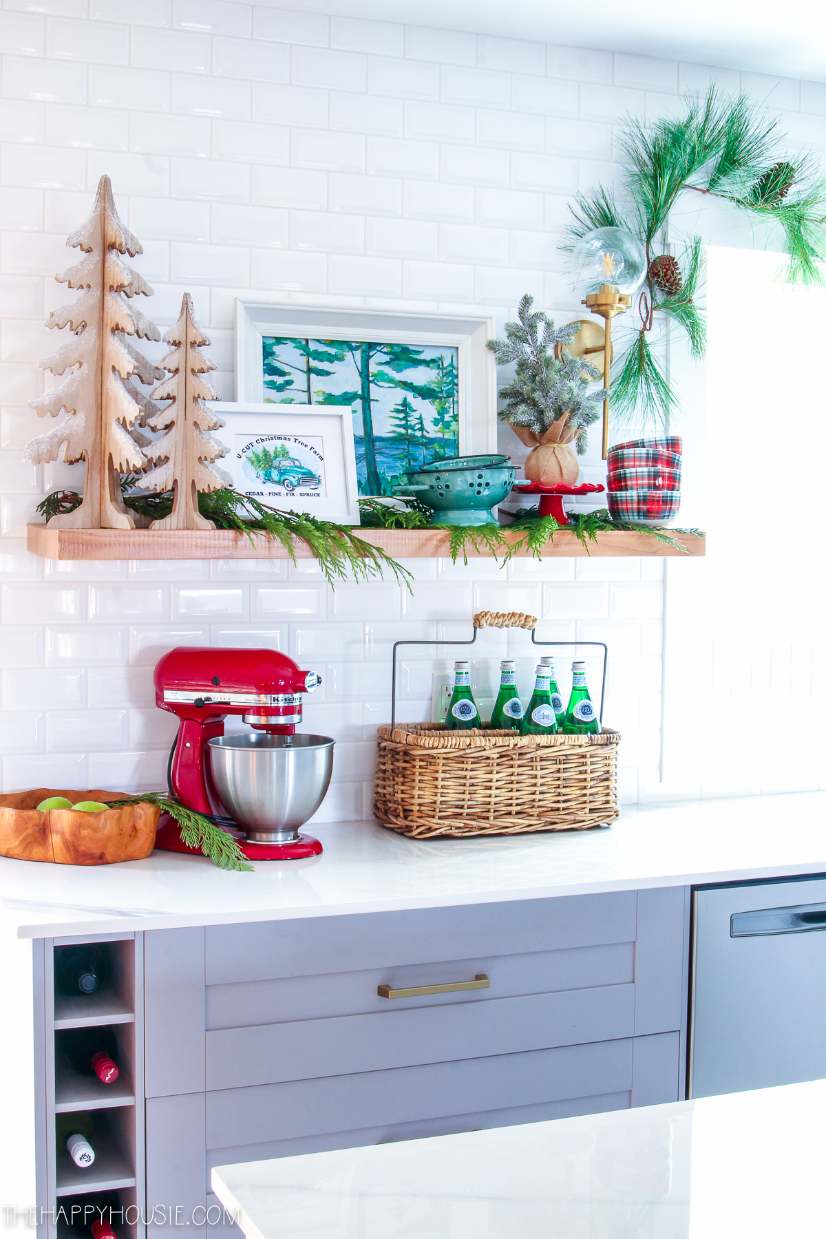 Love this cheery Christmas kitchen #christmasdecor #christmaskitchen #kitchenshelves #subwaytile #kitchenbacksplash #openshelves