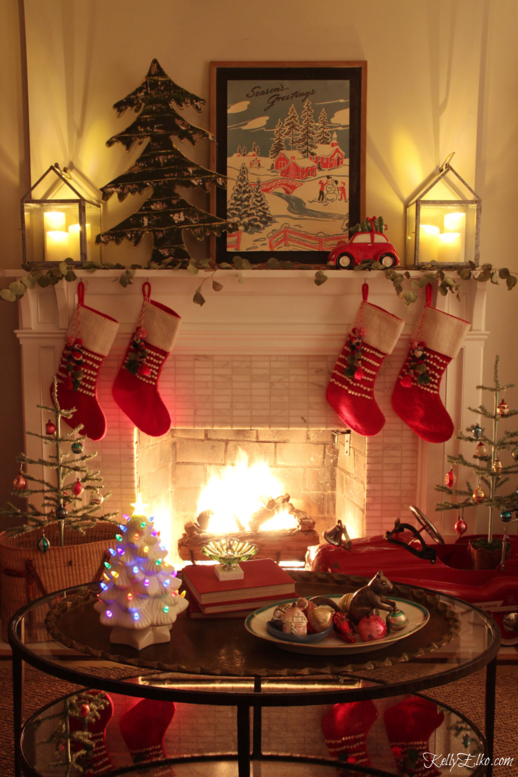 Christmas Night Tour - love the roaring fire on this Christmas mantel with lots of vintage touches kellyelko.com #christmasdecor #christmaslights #christmasmantel #christmasstockings #christmasart #vintagechristmas #christmasnightstour #kellyelko #colorfulchristmas #whimsicalchristmas 