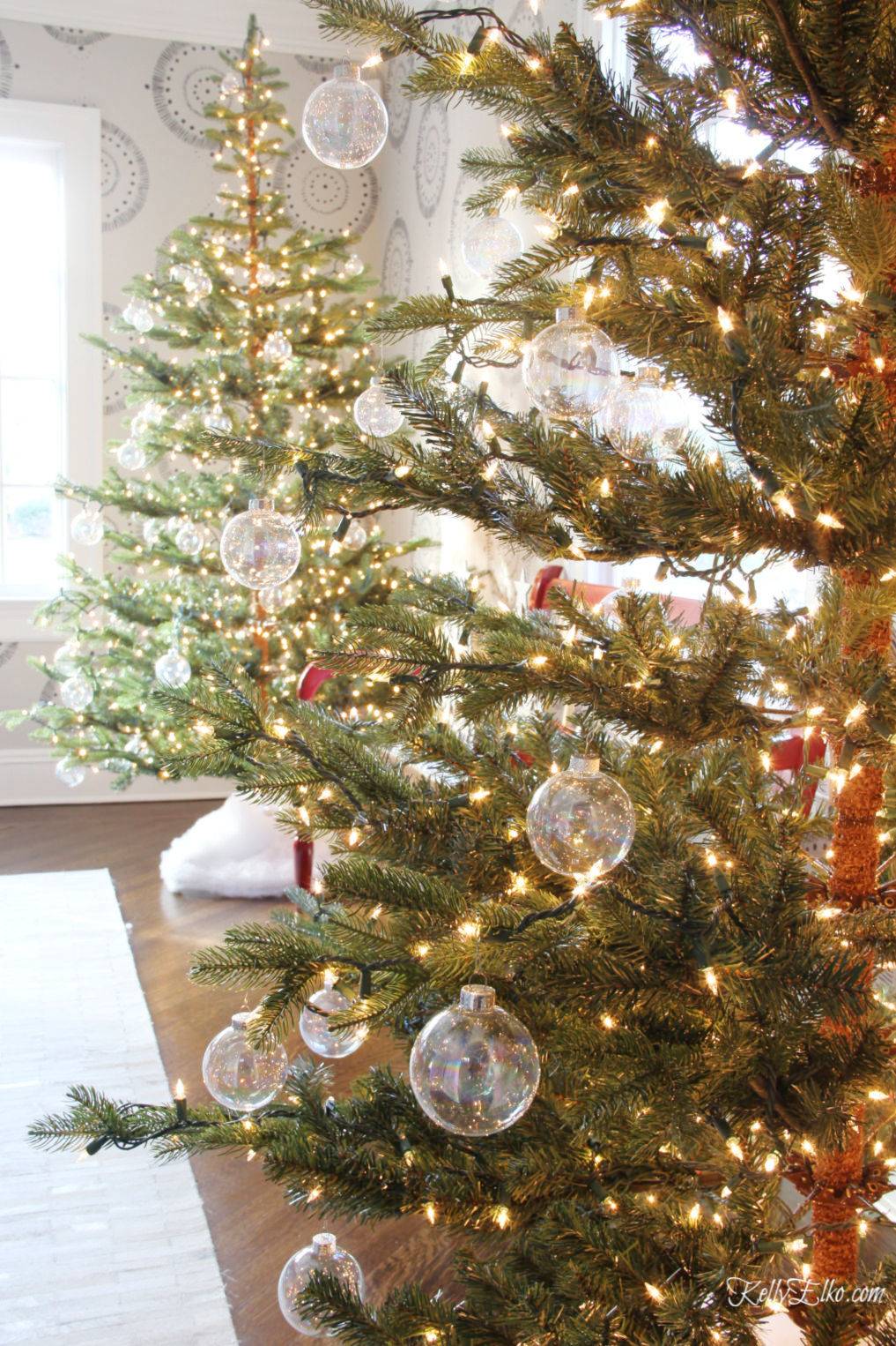 Beautiful Christmas Home Tour featuring a pair of sparse Christmas trees covered in clear glass ornaments kellyelko.com #christmas #christmasdecor #christmasdecorating #christmashome #christmastour #diychristmas #christmasideas #christmasmantel #christmastree #christmasornaments #vintagechristmas #farmhousechristmas #colorfulchristmas #creativechristmas #kellyelko