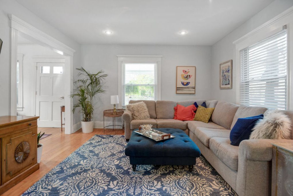 Slow decorating - she transformed this cozy family room with the right scale furniture and colorful accent pieces like the blue rug and ottoman kellyelko.com #livingroom #familyroomdecor #furnitureplacement #sectionalsofa #cozy #smallspacedecorating #blue #loloi #graypaint #beforeandafter