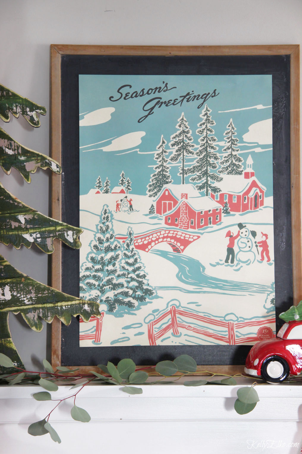 Beautiful Christmas Art of a little winter village with red barn kellyelko.com #christmas #christmasdecor #christmasdecorating #christmashome #christmastour #diychristmas #christmasideas #christmasmantel #christmastree #christmasornaments #vintagechristmas #farmhousechristmas #colorfulchristmas #creativechristmas #kellyelko #christmasart 