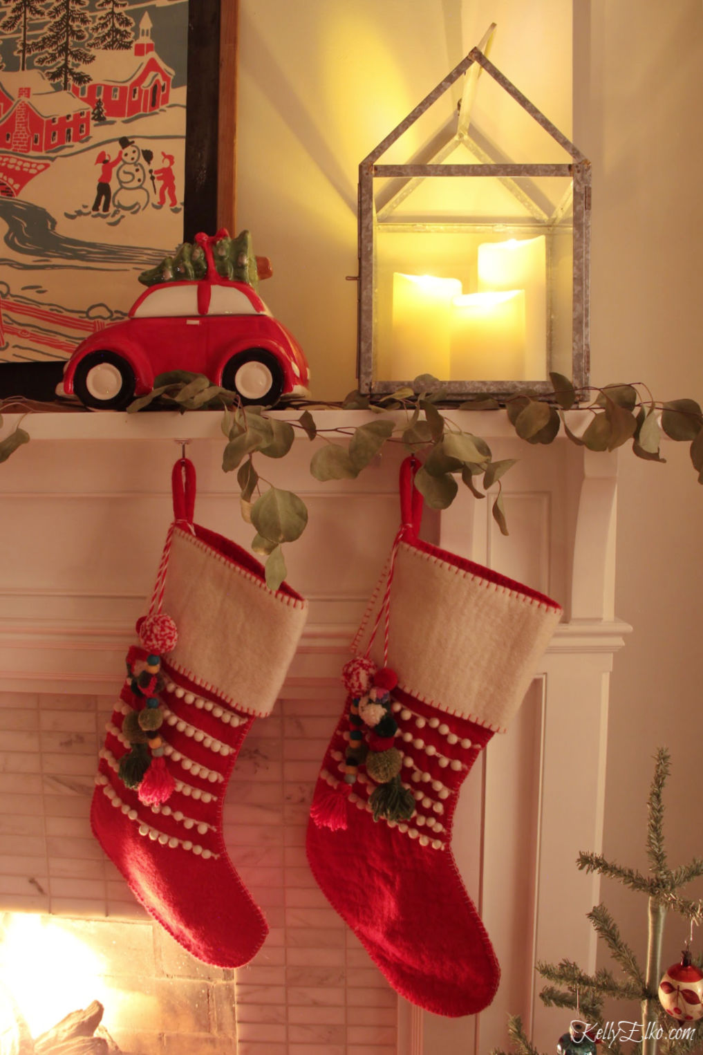 Christmas Night Tour - love the lanterns with candles and the pom pom stockings on the mantel kellyelko.com #christmasdecor #christmasmantel #christmasstockings #vintagechristmas #colorfulchristmas #farmhousechristmas #kellyelko 