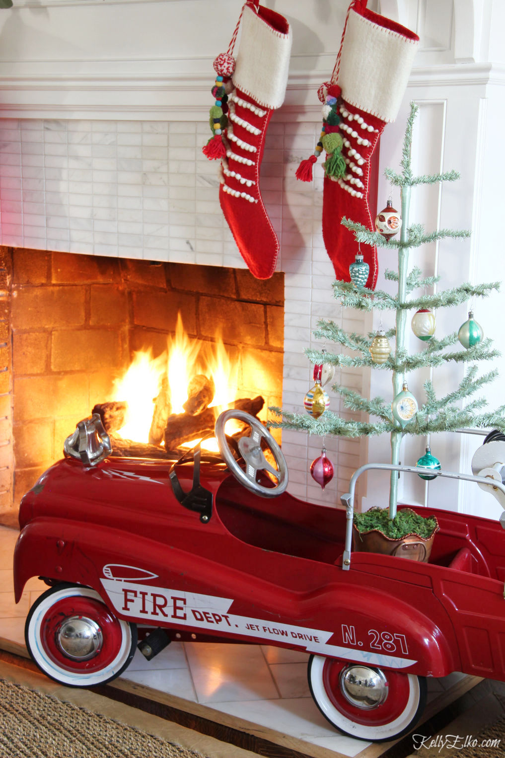 Vintage pedal car is a cute place to put a little Christmas tree kellyelko.com #christmasdecor #vintagechristmas #christmastree #feathertree #pedalcar #vintagetoys #christmasmantel #christmasstockings #kellyelko #farmhousechristmas 