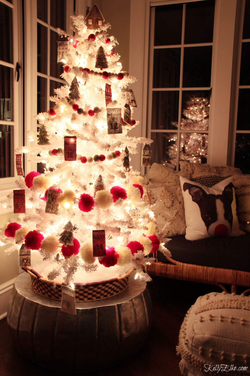 Glowing white Christmas tree with whimsical red pom pom garland kellyelko.com #christmasdecor #christmastree #whitechristmastree #whitetree #adventtree #adventcalendar #farmhousechristmas #whimsicalchristmas #farmhousechristmas #farmhousedecor #kellyelko