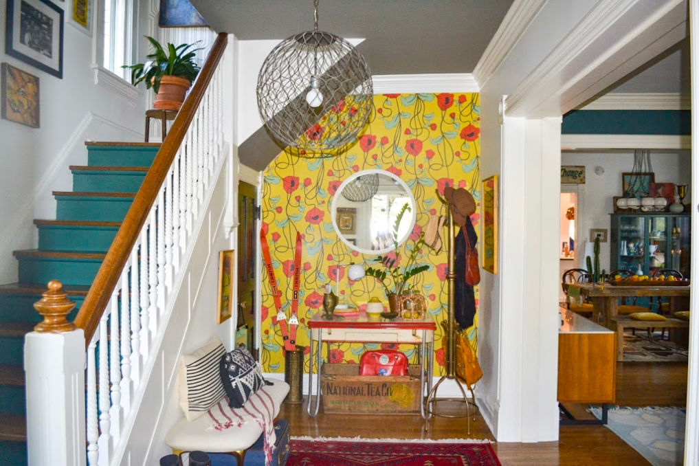 Colorful entry with red poppy wallpaper and blue painted stair risers #foyer #foyerdecor #entry #entrydecor #colorfuldecor #colorlovers #wallpaper #floralwallpaper #poppies #vintagedecor #eclecticdecor #hometour / kellyelko.com