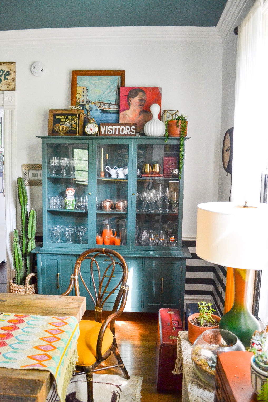 Beautiful vintage hutch painted blue and filled with a collection of vintage glassware #vintagedecor #vintagefurniture #paintedfurniture #bluefurniture #vintagecollections #collections #glassware #midcentury #portraits #diningroomdecor #eclecticdecor #vintagediningroom / kellyelko.com