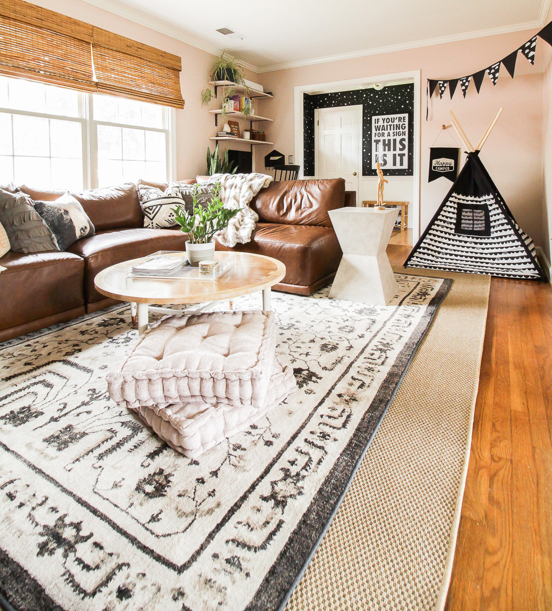 Cozy family room with leather sectional sofa and layered rugs