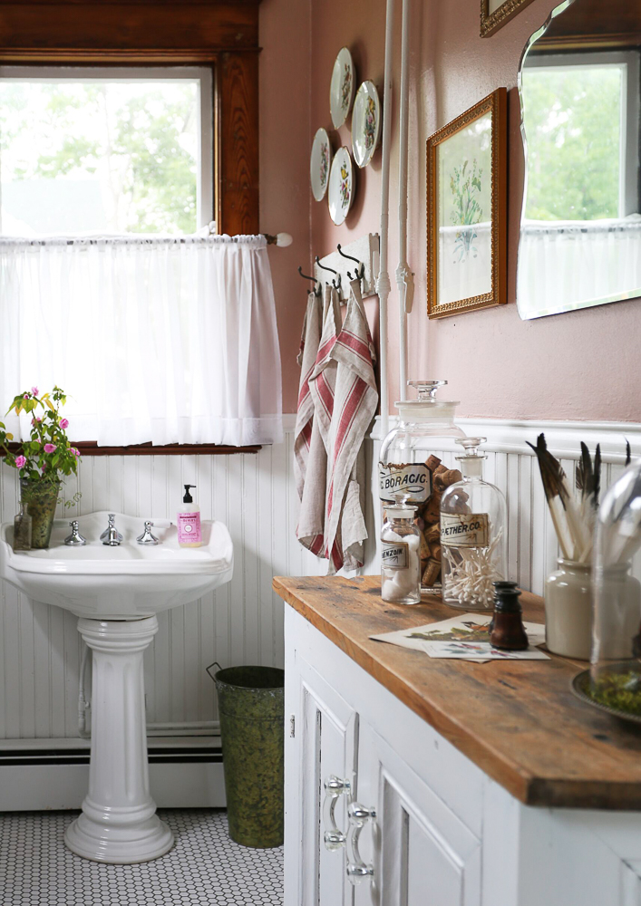 Charming farmhouse bathroom with pedestal sink and plate wall kellyelko.com #farmhouse #farmhousebathroom #powderroom #bathroomdecor #platewall #farmhousedecor