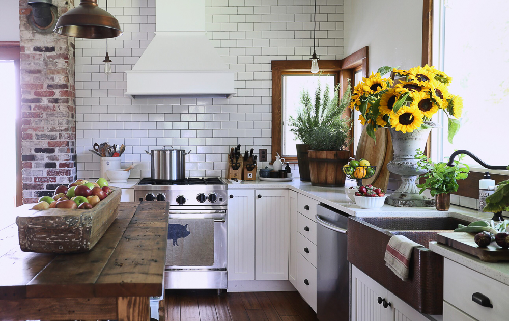 Love this charming farmhouse kitchen with wood table as an island and subway tile to the ceiling kellyelko.com #kitchen #countrykitchen #farmhousekitchen #farmhouse #farmhousedecor #sunflowers #subwaytile #backsplash 