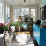 How to Hang Art on Windows and a Colorful Eclectic Plant Filled Sunroom kellyelko.com #art #sunroom #plantlady #houseplants #sunroomdecor #sunroomfurniture #vintagedecor #eclecticdecor #midcentury #paintedfurniture