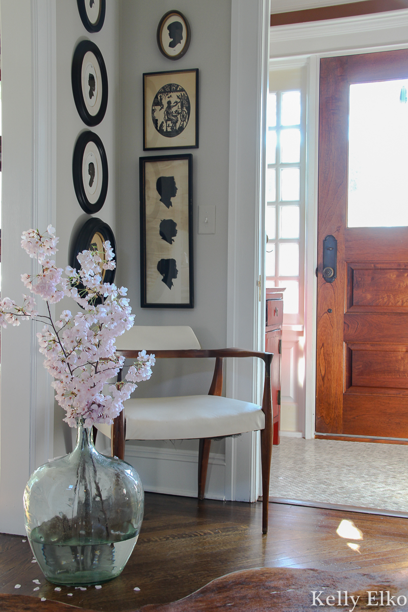 Love the graphic punch these vintage silhouettes add to this foyer kellyelko.com #foyer #foyerdecor #art #vintageart #silhouettes #vintagesilhouettes #eclecticdecor #farmhousedecor #cherryblossom #floweringbranches #midcenturydecor #oldhouse #oldhome #vestibule