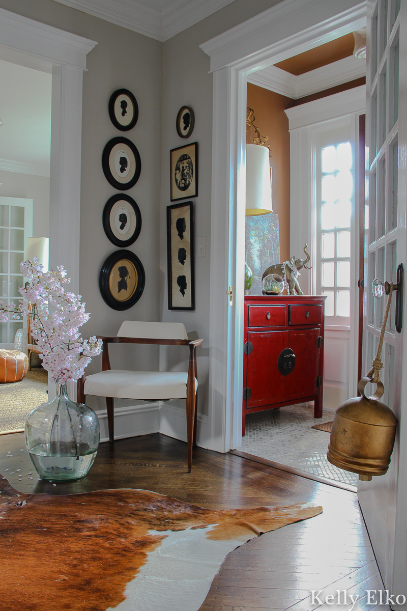 Vintage silhouette gallery wall - love the graphic black and white in this eclectic foyer kellyelko.com #gallerywall #silhouettes #vintageart #vintagesilhouettes #blackandwhite #foyer #foyerdecor #eclecticdecor #oldhome #oldhouse #eclecticstyle #fixerupperstyle #vestibule #cowhide #floweringbranches