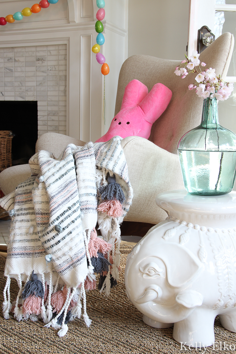 Love this spring decor with tassel throw and pink Peep pillow! kellyelkol.com #spring #springdecor #bohodecor #tassels #peeps #elephantdecor #eclecticdecor #easterdecor #kellyelko #cherryblossom