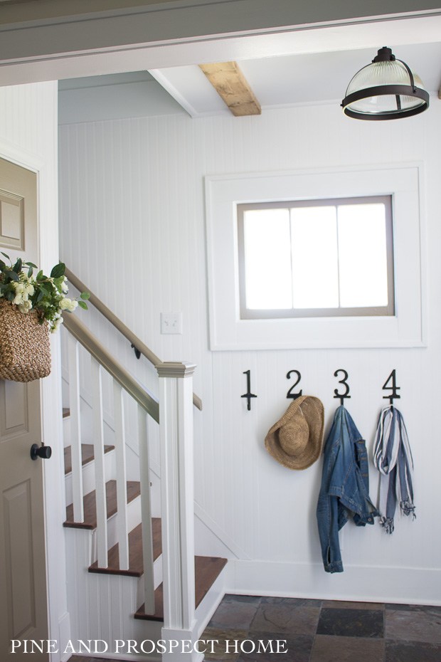 Farmhouse foyer with numbered coat hooks #farmhousefoyer #foyer #entrydecor #farmhousedecor #vintagedecor #neutraldecor #beadboard 