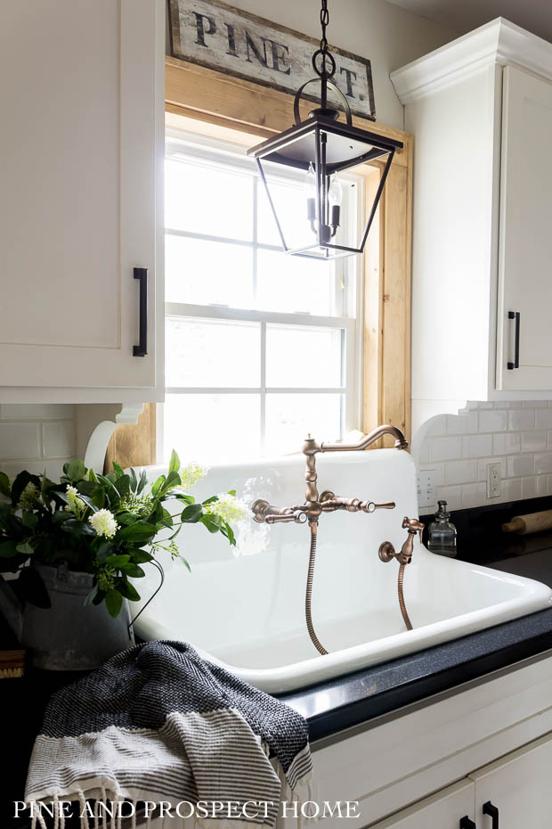 Beautiful white farmhouse kitchen with vintage looking high back sink and copper faucet #kitchen #vintagekitchen #kitchensink #vintagedecor #farmhousekitchen #farmhousedecor #kitchenwindow