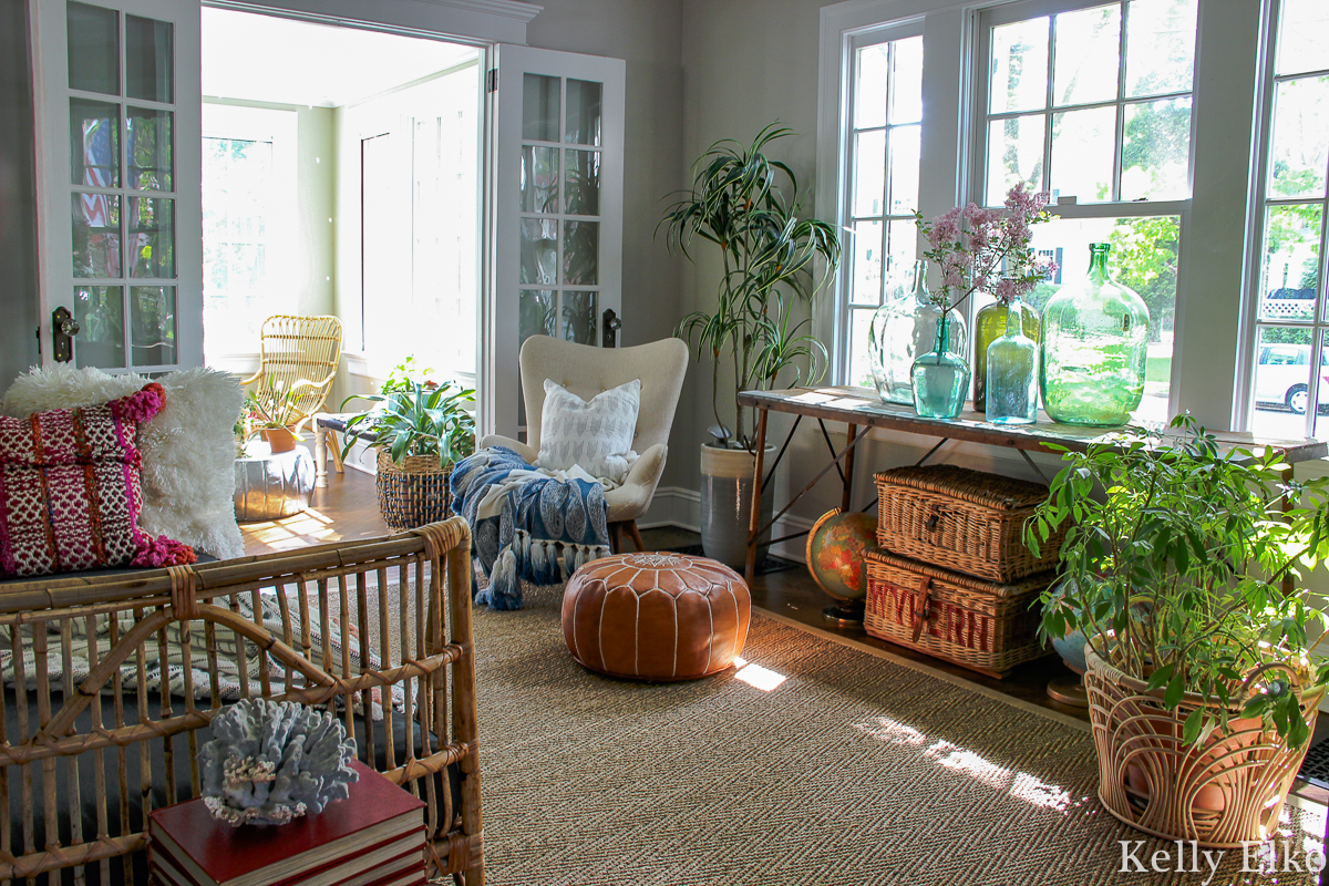 Eclectic boho living room filled with plants, vintage finds and lots of texture from rattan, leather tassels, wicker and more kellyelko.com #vintagedecor #eclecticdecor #bohodecor #livingroomdecor #plantlady #houseplants #vintagecollections #collections #vintageglass #demijohn #rattan #daybed #interiordecor #interiorstyling #cozydecor #kellyelko