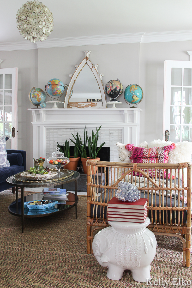 Eclectic living room with rattan daybed and vintage globe collection displayed on the mantel kellyelko.com #vintagedecor #globes #vintageglobes #collections #collect #vintagemodern #bohodecor #rattan #rattanfurniture #article #daybed #livingroom #kellyelko