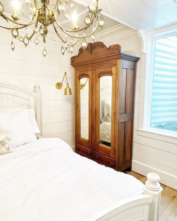 Farmhouse white bedroom with shiplap walls, brass lighting and antique hutch kellyelko.com #hutch #antique #antiquefurniture #farmhouse #farmhousedecor #farmhousebedroom #shiplapbedroom #whitebedroom #neutraldecor #vintagedecor #brasslighting