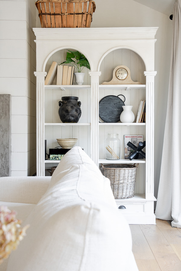 Beautiful arched bookshelf with unique vintage display #bookshelves #neutraldecor #farmhouse #farmhousedecor #vintagedecor #vintagemodern #cottagedecor 