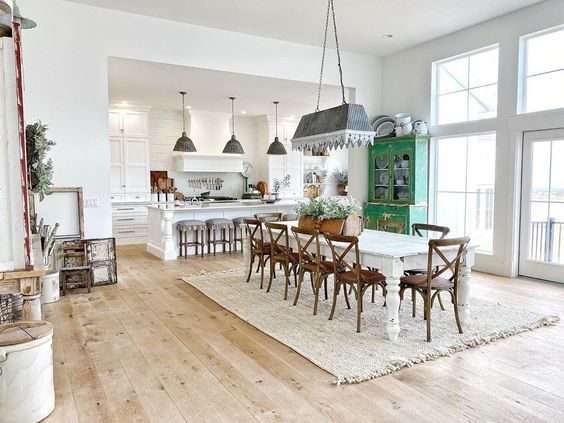 Love this open farmhouse dining room and kitchen with painted furniture and galvanized lighting kellyelko.com #lighting #greatroom #openfloorplan #farmhouse #farmhousedecor #farmhousestyle #farmhousediningroom #diningroom #diningroomdecor #vintagedecor 