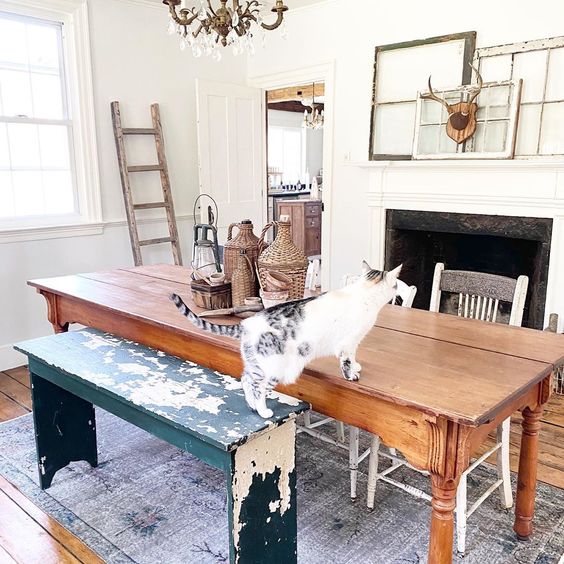 Charming farmhouse dining room with mismatched table and chairs and a mantel of antique mirrors #antiques #vintage #diningroom #diningroomdecor #diningroomfurniture #vintagedecor #vintagefurniture #manteldecor #farmhouse #farmhousedecor #farmhousediningroom #fixerupperstyle #shabbychic