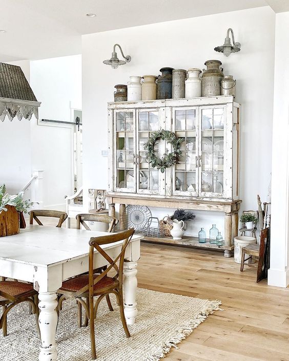 Eclectic Home Tour of Sweet Pickins - love the collection of vintage milk cans kellyelko.com #farmhouse #farmhousedecor #housetour #hometour #farmhousestyle #vintagedecor #vintage #collections #milkcans #neutraldecor #vintagediningroom #farmhousediningroom #galvanized #sconces #hutch 